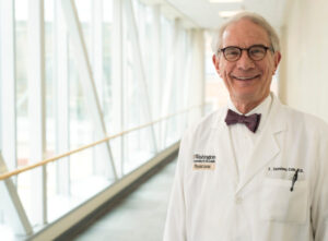 F. Sessions Cole, M.D. in a white coat and bow tie smiling.